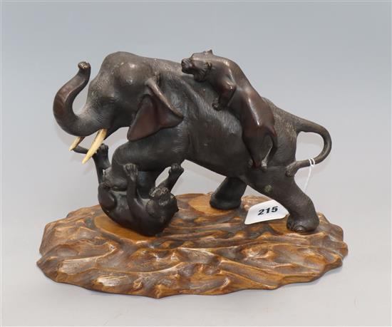 A Japanese Meiji period bronze figure of tigers attacking an elephant, signed, on carved wood base Height including base 21.5cm